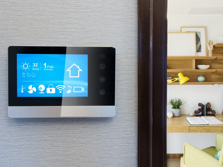 Smart-Home-Bedienfeld, im Hintergrund das Wohnzimmer